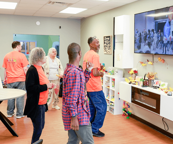 Group of adults dancing along to a video