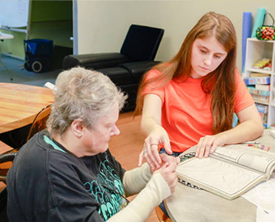 Older woman being helped by a staff member