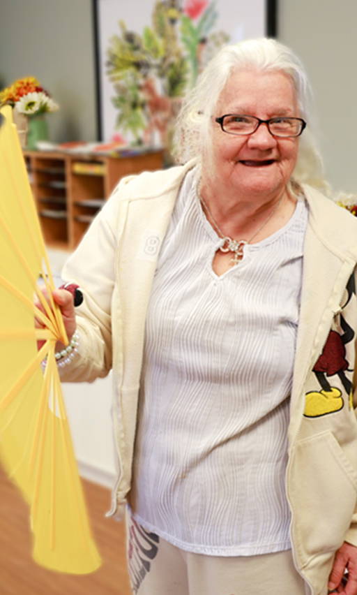 Older woman waving a fan and smiling