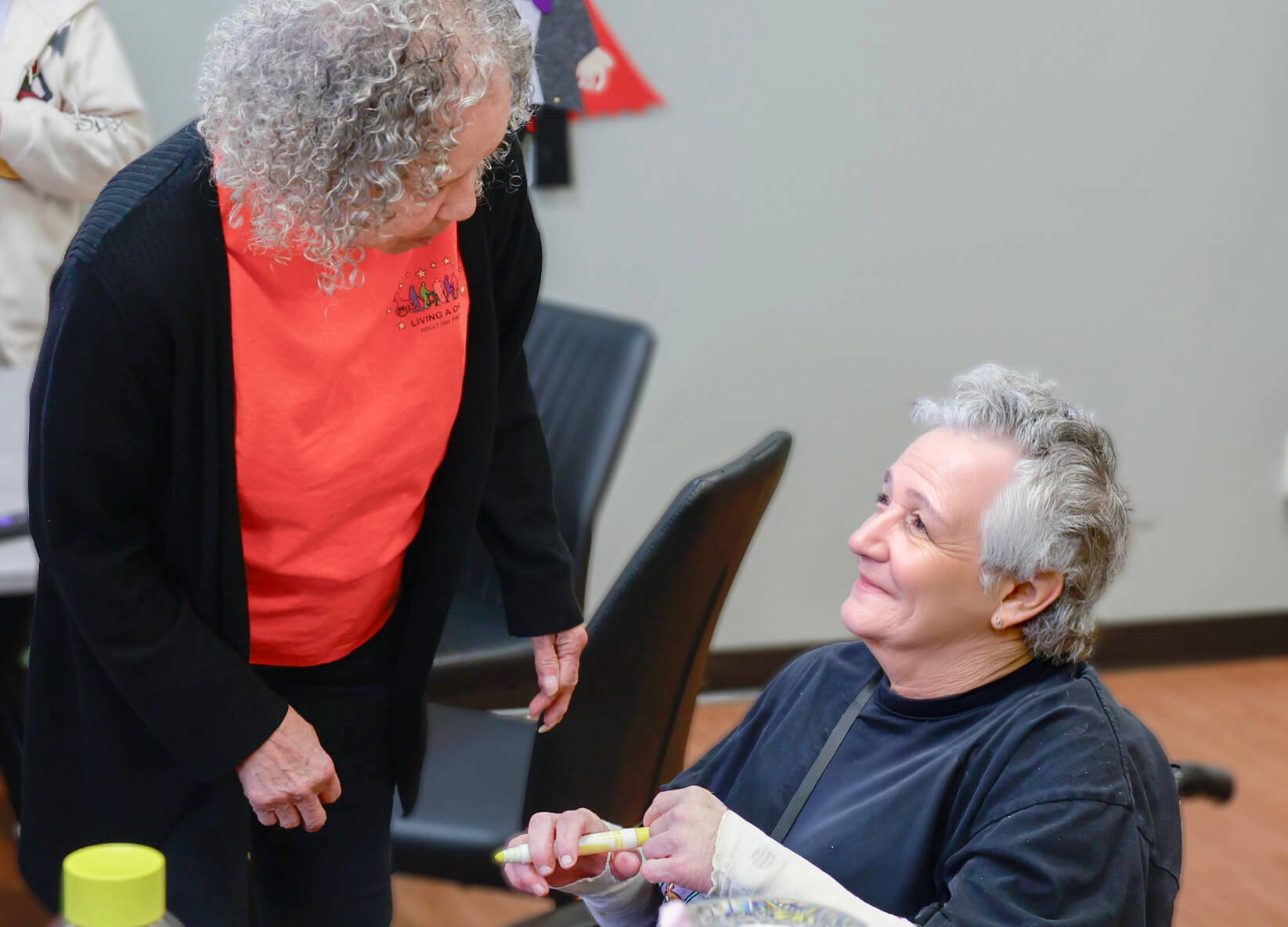 Seated older woman speaking with a staff member