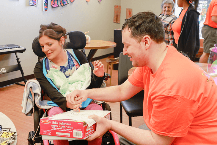 Living a Dream staff member helping a woman in a wheelchair